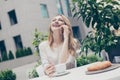 Pretty, cute, smiling woman having breakfast, brunch in cafe t Royalty Free Stock Photo