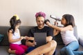 Cute daughters are painting the nails and combing the hair of their handsome young father Royalty Free Stock Photo