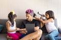 Cute daughters are painting the nails and combing the hair of their handsome young father Royalty Free Stock Photo