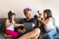 Cute daughters are painting the nails and combing the hair of their handsome young father Royalty Free Stock Photo