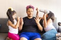 Cute daughters are painting the nails and combing the hair of their handsome young father Royalty Free Stock Photo