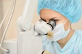 Pretty doctor woman portrait. Ophthalmology laser microscope operation. Clinic room. Patient eye treatment. Myopia and cataract Royalty Free Stock Photo