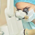 Pretty doctor woman portrait. Ophthalmology laser microscope operation. Clinic room. Patient eye treatment. Myopia and cataract Royalty Free Stock Photo