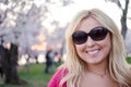 Pretty dusk sunset portrait of a Blonde Woman posing by Cherry Blossoms flowers Royalty Free Stock Photo