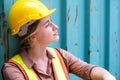 Pretty engineer worker sitting on the floor in front of the container, feeling sad and disappointed Royalty Free Stock Photo