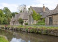 Pretty english village with stone houses, river, wild flowers Royalty Free Stock Photo