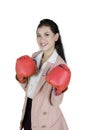 Pretty entrepreneur wearing boxing gloves on studio
