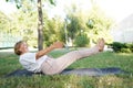 A pretty European adult woman is doing morning routine. The athletic woman istretching her body outside. She is at the park Royalty Free Stock Photo