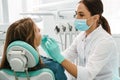 European mid dentist woman in face mask working in dental clinic