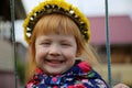 Pretty European red-haired girl in a wreath from yellow dandelions Royalty Free Stock Photo