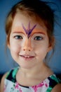 Pretty exciting blue-eyed girl of 2 years with a face painting Royalty Free Stock Photo