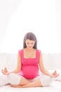 Pretty expectant mother is meditating at home Royalty Free Stock Photo