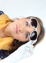 Pretty expressive lady wearing a polka dots dress white sunglasses and yellow scarf in the studio