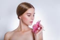 Pretty face of beautiful young woman with pink lily on hands. Concept for skin care or organic cosmetics Royalty Free Stock Photo