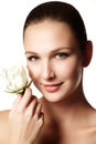 Pretty face of beautiful young woman with rose on hands - white