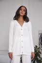 Pretty fashion beautiful woman sexy lady brunette curly hair dark tanned skin wear trend clothes white knitted suit jacket top