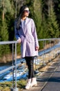 Pretty woman posing with sunglasses and violet coat