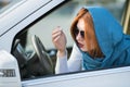 Pretty fashionable business woman driver in scarf and sunglasses checking her makeup in a mirror Royalty Free Stock Photo