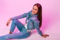 Pretty fashionable happy young woman with lovely smile in stylish youth blue jeans clothes rest and positive smiling near vintage Royalty Free Stock Photo