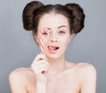 Pretty fashionable woman with pink makeup and perfect updo hairdo holding candy near her face Royalty Free Stock Photo