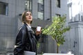 Pretty fashionable young business woman, freelance, copywriter, blogger walking along the street with laptop under arms and