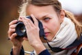 Pretty female amateur photographer taking photos outdoors Royalty Free Stock Photo