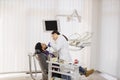 Pretty female asian dentist in white uniform, making dental check up and caries treatment with drill