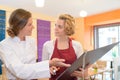 Pretty female chef and waitress discussing menu Royalty Free Stock Photo