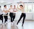 Pretty female choreographer conducting classes in ballet studio shows group correct performance Royalty Free Stock Photo