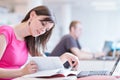 Pretty female college student in the library