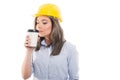 Pretty female constructor smelling takeaway coffee