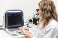 Pretty female doctor, posing while is doing a sonography. Female doctor wearing white coat, holding a ultrasound device Royalty Free Stock Photo