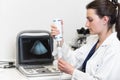 Pretty female doctor, posing while is doing a sonography. Female doctor wearing white coat, holding a ultrasound device Royalty Free Stock Photo