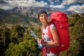 Pretty, female hiker in high mountains using a map Royalty Free Stock Photo