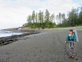 A pretty female hiker standing on the beach of the West Coast Trail, on Vancouver Island, British Columbia, Canada.