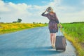 Woman hitchhiker with suitcase Royalty Free Stock Photo