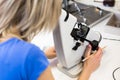 Pretty, female optometrist measuring newly made glasses