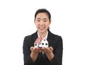 Pretty female real estate salesperson smiling in front of white background holding small house model Royalty Free Stock Photo