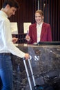 A pretty female receptionist taking data from the guest at the hotel. Tourism, business, hotel Royalty Free Stock Photo