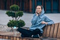 Pretty female sitting with crossed legs, listening to msic. Royalty Free Stock Photo