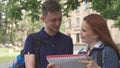 Female student asks her classmate about something in notebook on campus Royalty Free Stock Photo