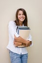 Pretty female student holding books in her hands