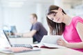 Pretty female student with laptop and books