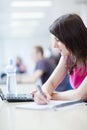 Pretty female student with laptop and books