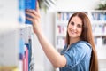 Pretty female student with laptop and books working in a high school library Royalty Free Stock Photo