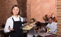 Pretty female waiter showing country restaurant