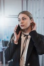 Pretty female worker stands at office and talks on the phone Royalty Free Stock Photo