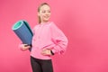 pretty female youngster holding fitness mat, isolated