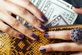 Pretty fingers of african american woman holding money closeup with purse, luxury jewellery on python clutch, cash for