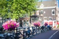 Pretty flowers and many bikes along a canal bridge in Amsterdam
